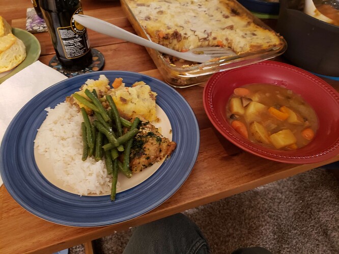 A plate of rice with each of the solid dishes, with a bowl of curry.