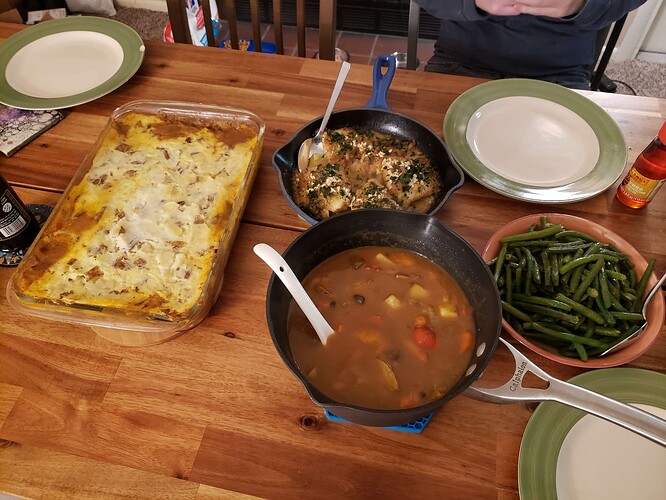 A full Thanksgiving spread, consisting of a shepherd's pie, baked cod, green beans, and a Japanese veggie curry.