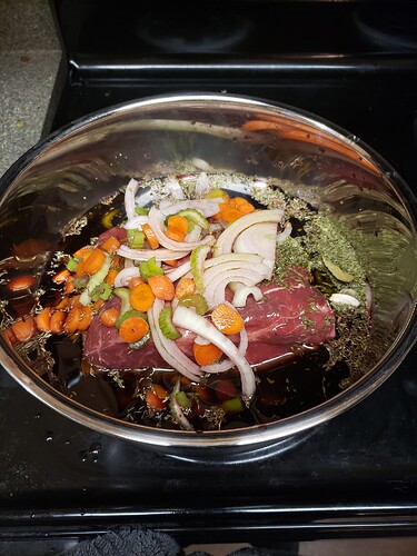 The same bowl, now full of red wine and scattered veggies and herbs.